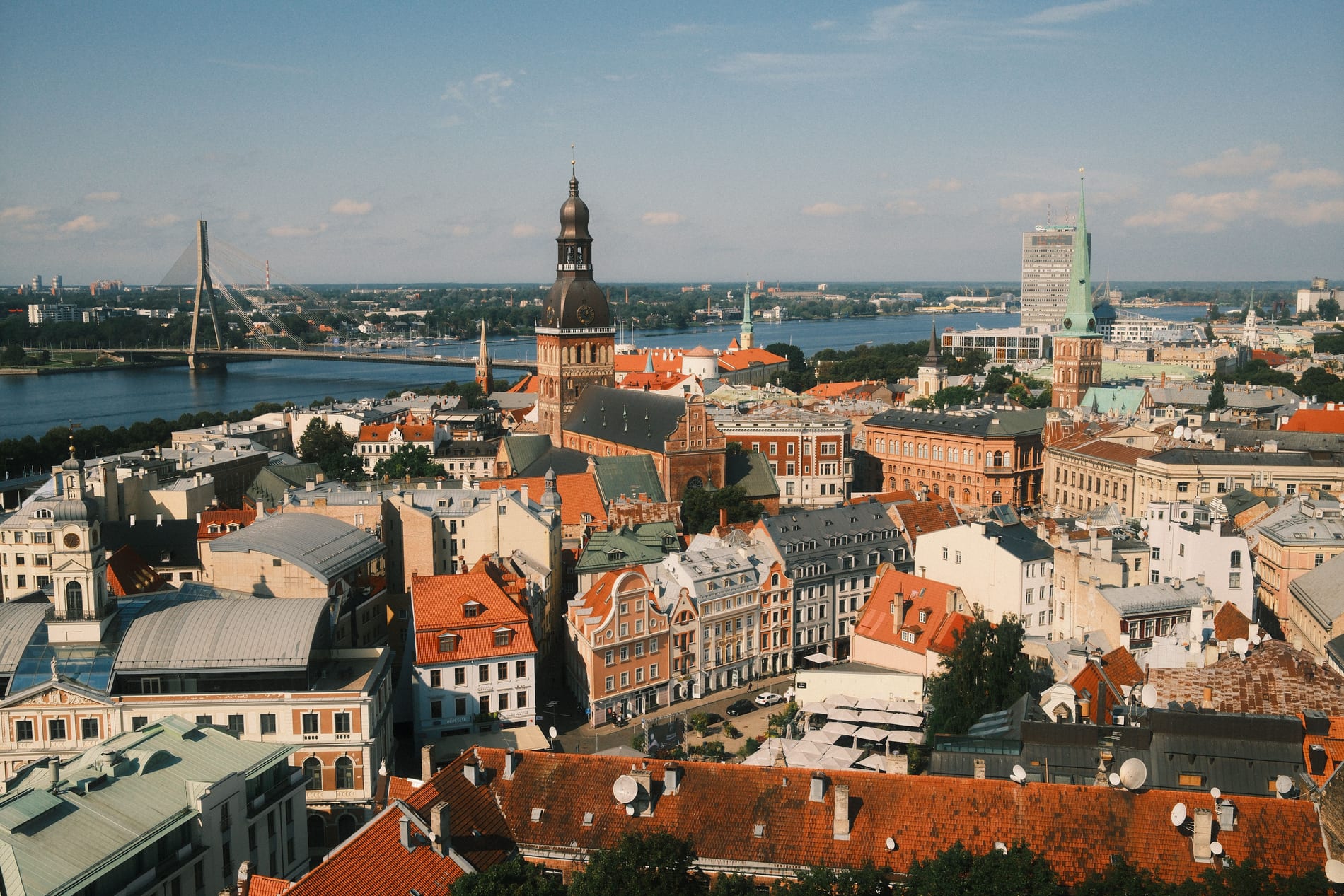 An aerial view of Rīga's Old Town, with the Daugava river, Riga Cathedral and red tiled roofs.